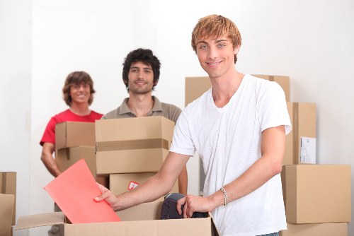 Professional movers carrying furniture through a narrow central London entrance